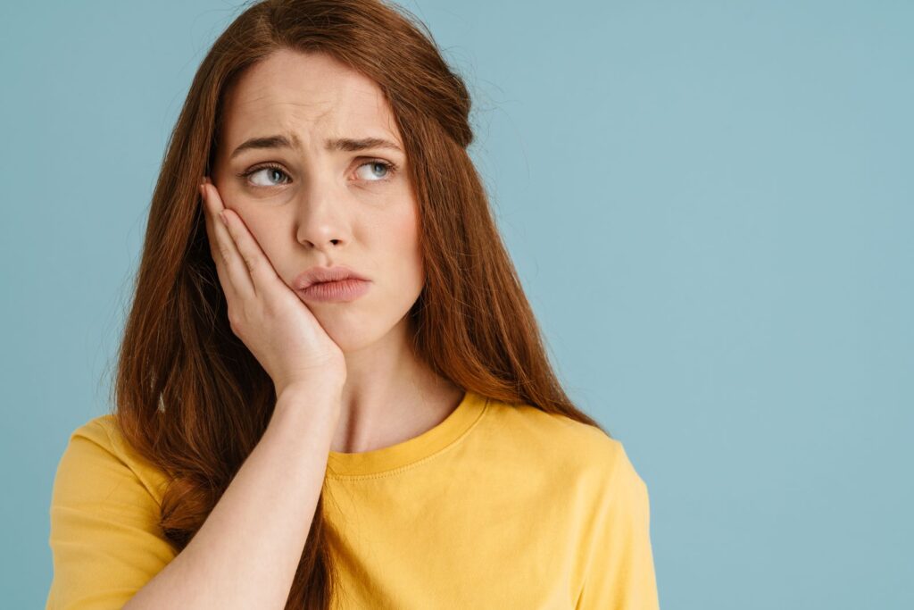 A woman with a toothache holding her jaw.